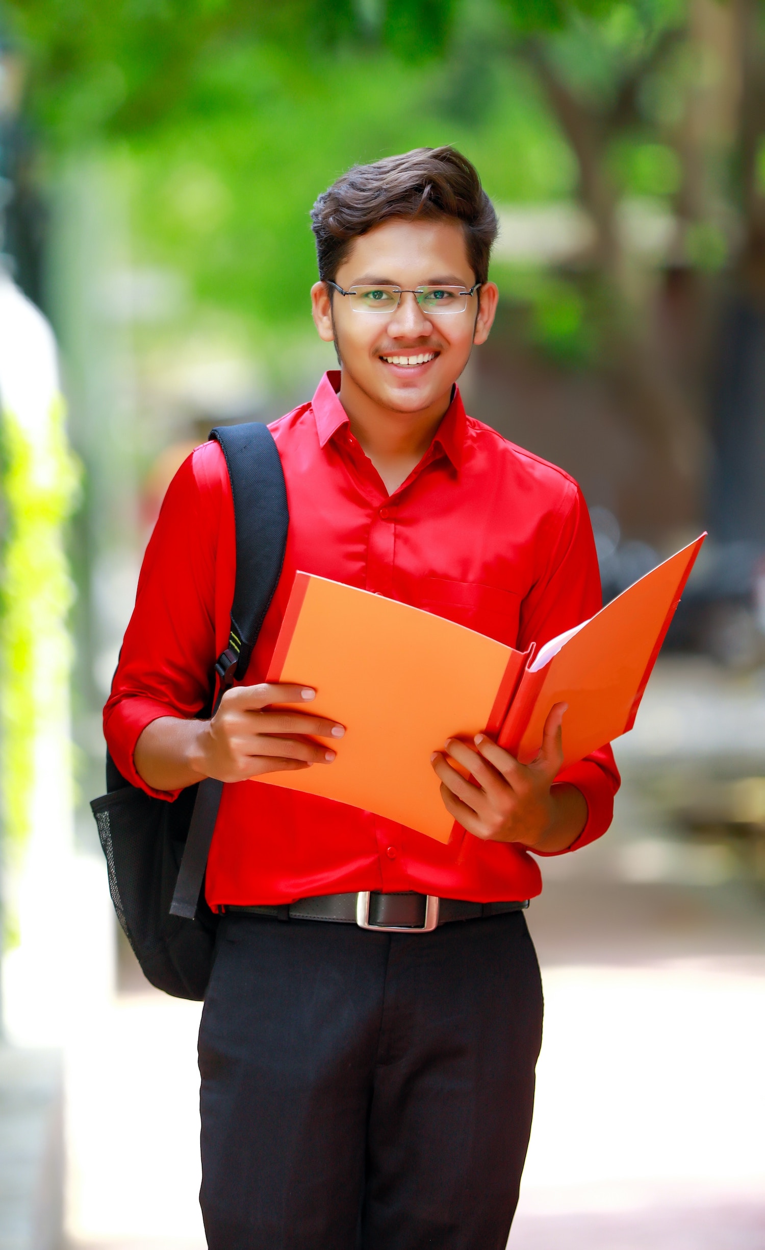 A boy in a red shirt holding a folder